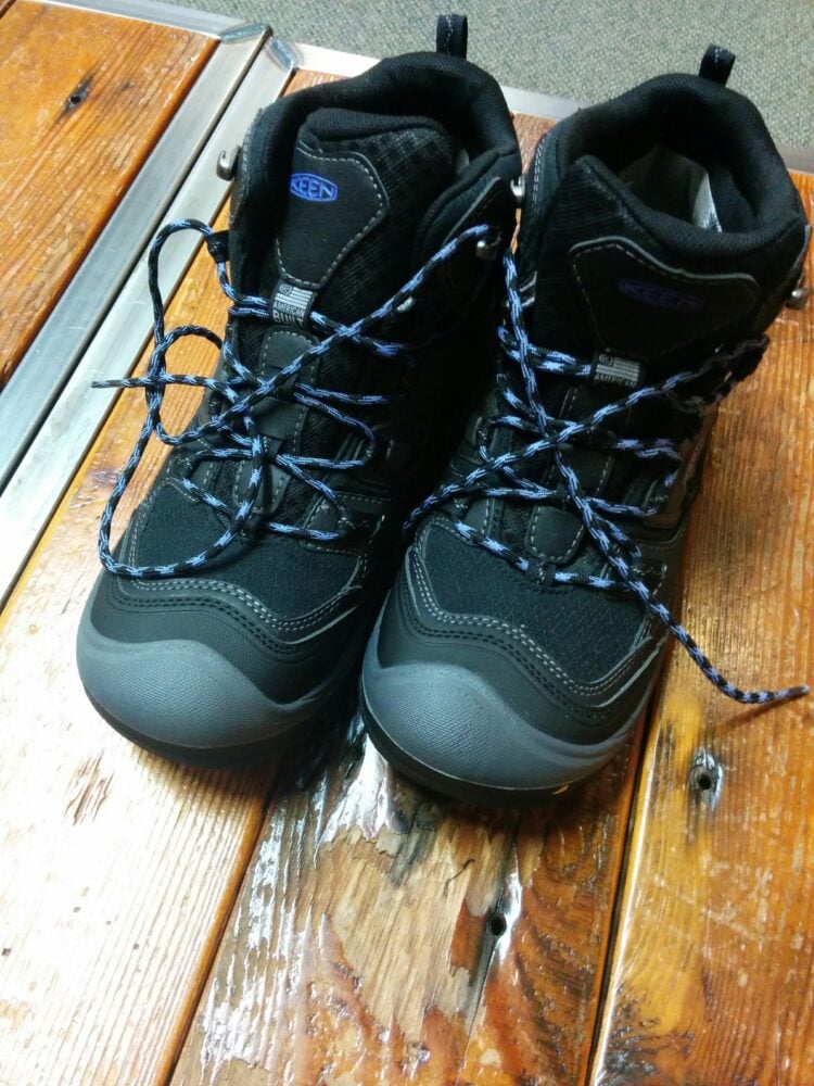 image: women's black Keen boots on wooden floor
