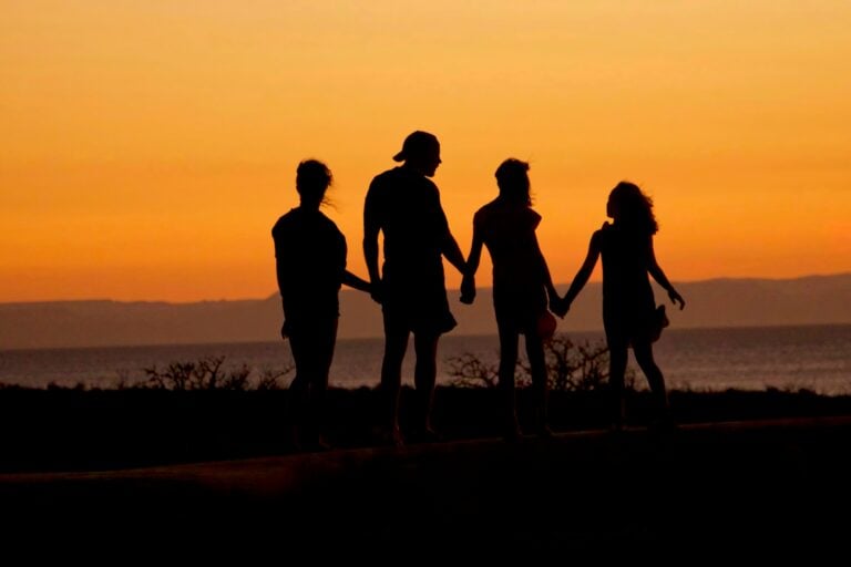 family silhouetted against sunset